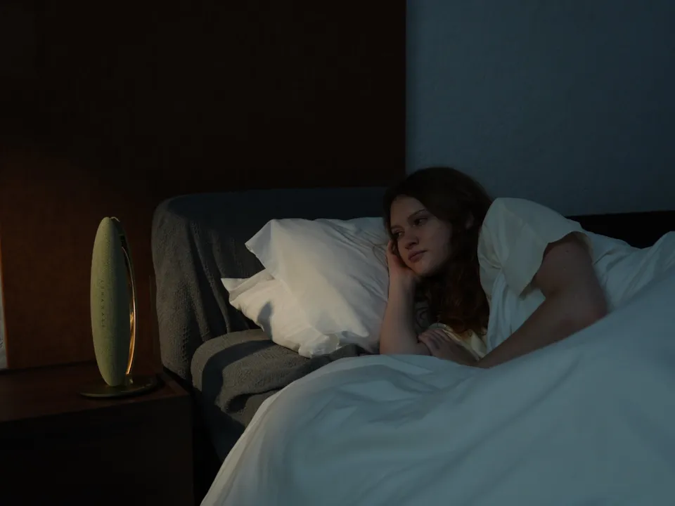 Person resting in bed beside LunaWake as the room grows quiet
