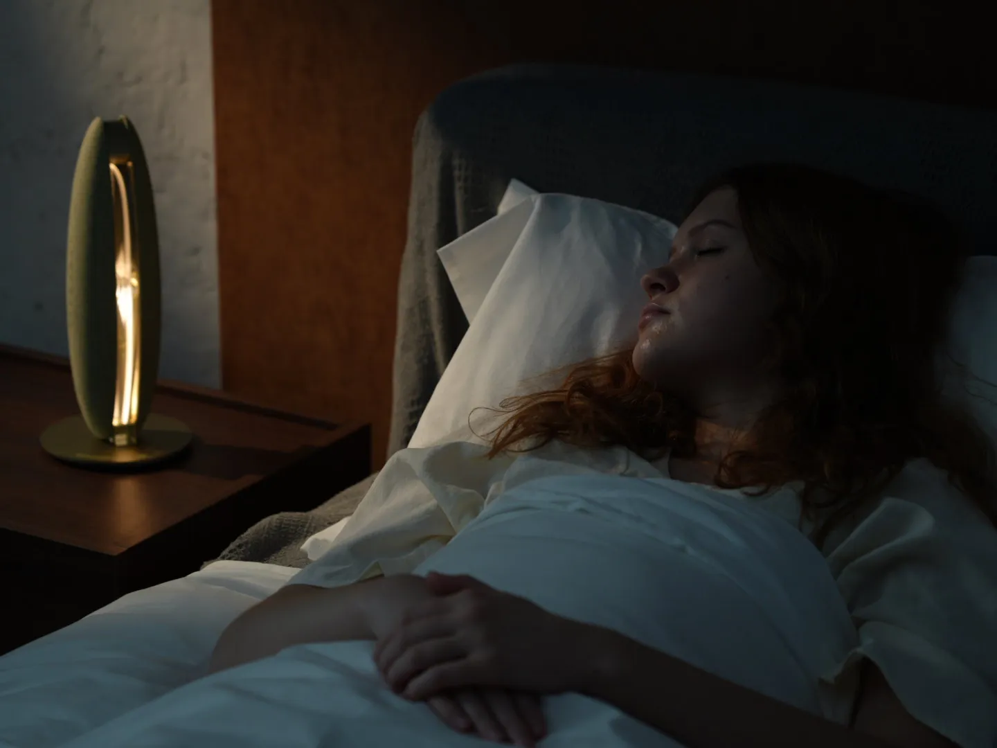 Person sleeping beside LunaWake in a real bedroom